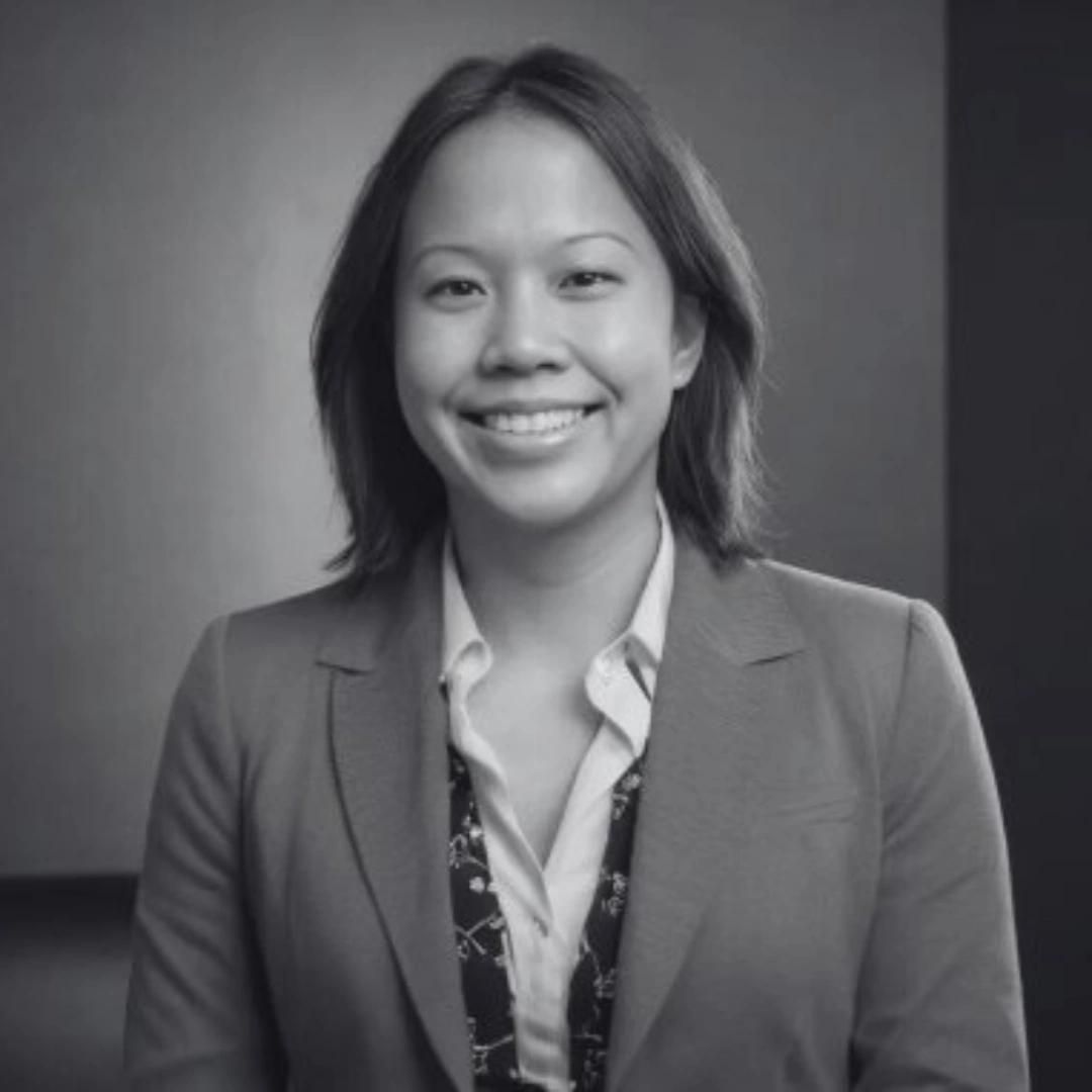 A headshot of Lilian smiling straight at the camera in black and white.